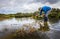 Scientist measuring water depth to install water level data loggers in a coastal wetland