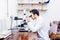 Scientist with microscope, examining samples and contaminated probes in special laboratory