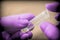 Scientist with pink latex gloves manipulates vial in laboratory