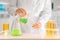 Scientist pouring color liquid into test tube in laboratory