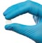 Scientist in protective gloves holding pill on white background, closeup