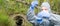 Scientist in a protective suit and mask, collects a sample of water in a flask with a blue liquid, close-up, there is a place for