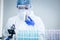 Scientist or researcher hand in blue gloves holding flu, measles, coronavirus, covid-19 vaccine disease