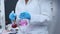 Scientist in rubber gloves and lab coat mixing pink liquids in the glass flasks, conducting of experiment