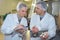 Scientist speaking to colleague holding clipboard in factory