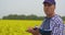 Scientist Thinking And Writing In Clipboard At Rapeseed Field