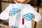 Scientist wear white coat and blue gloves holding dropper and drop red water to tube science. Chemist examines chemical test tube