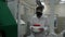 Scientist wearing protective suit and carrying a jar of toxic liquid inside a biohazard area