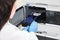 Scientist in a white lab coat putting vial with a sample into autosampler of HPLC system. High performance liquid