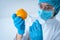 Scientist woman making laboratory research, holding syringe in hands, making injection in vegetable