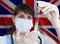 Scientist woman with test tube Coronavirus or COVID-19 against Great Britain flag. Research of viruses in laboratory