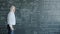 Scientist writing formulas on chalkboard underlining equation teaching science in class
