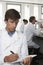 Scientist Writing On Notepad In Laboratory