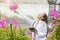 Scientists are enjoying their work. Positive young asian at gardening specialist in orchids. botanist or biologist holding tablet