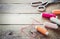 Scissors, bobbins with thread and needles. Old sewing tools on the old wooden background. Vintage Background