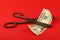 Scissors cut US dollars over red background