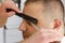 Scissors cutting eyebrow of man at barbershop. Brow grooming close up