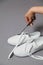 Scissors hand cuts label off new white sneakers