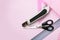 Scissors, paper knife, rulers on a pink background, top view with copyspace. Handicraft, origami, hobby and motor development