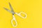 Scissors on solid yellow background with copy space using as haircut fashion or cost expense or budget cut and reduction