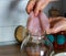 Scoby, hands holding tea mushroom in glass jar.
