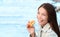 Scone pastry Asian woman eating british cake dessert by the sea portrait. Young model smiling at camera holding bakery