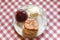 Scone and strawberry jam and clotted cream on a plate on a table with table cloth