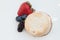 Scones with strawberries, blueberry and mulberry on wooden table