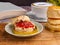 Scones traditional English delicious freshly baked homemade with strawberry jam and served on a wooden tray with a coffee cup.