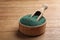 Scoop in bowl of spirulina powder on table