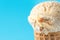 Scoop of Delicious Melting Salted Caramel Toffee Vanilla Ice Cream in Waffle Cone on Blue Background