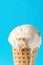 Scoop of Delicious Melting Salted Caramel Toffee Vanilla Ice Cream in Waffle Cone on Blue Background. Summer Sweets