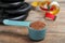 Scoop with protein powder, measuring tape and dumbbell plates on wooden table