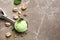 Scoop with tasty pistachio ice cream on grey table, flat lay