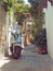 A scooter parked in a narrow typical quiet cobbled street in rhodes town with old yellow painted houses and a stone arch with