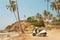 Scooter parked under the palm trees of a beautiful beach in Goa, India