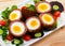 Scotch eggs with tomatoes, greens and leek, traditional Scottish cuisine