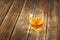 Scotch on wooden background with copyspace. An old and vintage table with glass of liquor .