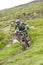 Scotland - August 14, 2010: Cyclists descending down a steep slope among the muddy mountains