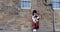 Scotland, United Kingdom - May 30, 2019: Scottish piper in traditional costume plays on Edinburgh street. 4K Footage.