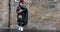 Scotland, United Kingdom - May 30, 2019: Scottish piper in traditional costume plays on Edinburgh street. 4K Footage.