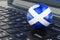 Scottish flag on laptop keyboard. Online business, education, shopping in Scotland concept. 3D rendering