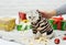 Scottish fold-eared kitten in a tiger costume sits against the background of Christmas gifts with a disgruntled angry