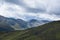 Scottish Highland hillsides in shifting colours against cloudy s