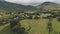 Scottish village cottages, houses at road aerial. Whiskey distillery at mountain. Nature landscape