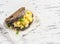 Scramble egg sandwich on a light wooden background.