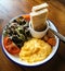 Scramble egg with vegetable and tomato salad and toast on wooden table