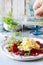 Scramble of eggs with carpaccio of baked beets with walnuts, aromatic herbs and arugula on a plate. Delicious healthy breakfast.