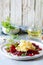 Scramble of eggs with carpaccio of baked beets with walnuts, aromatic herbs and arugula on a plate. Delicious healthy breakfast.