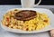 scramble eggs and hash browns top with sausage patty